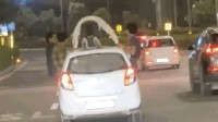 印度一男子在行驶车顶做俯卧撑喝酒 警方已将其拘留